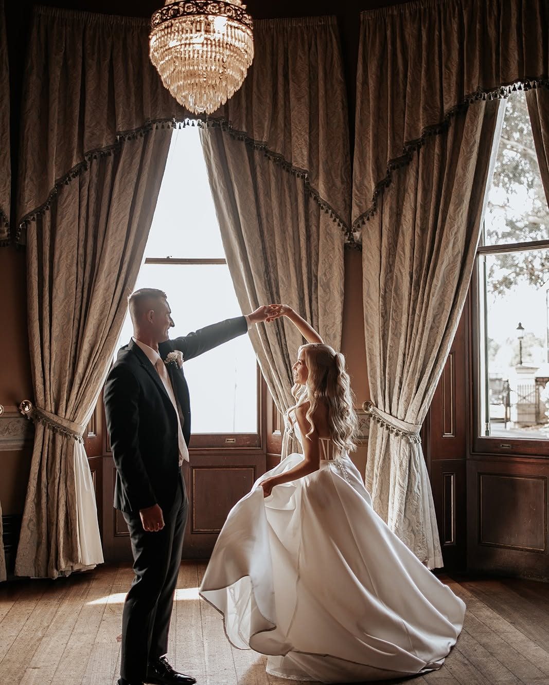A couple dancing in the Ballroom bay window beneath the chandelier