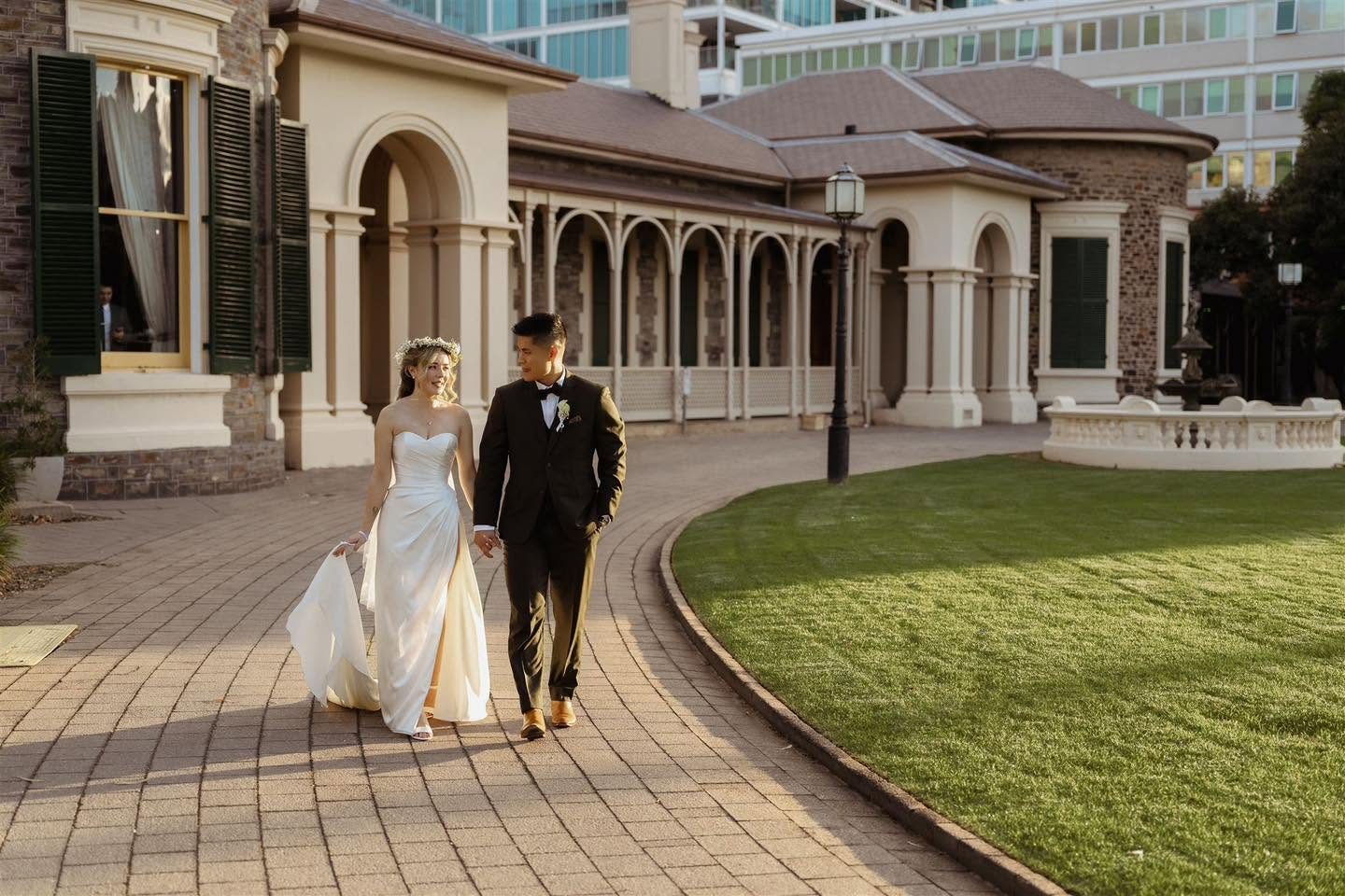 A couple walking along the path in front of Ayers House